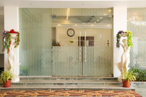 a lobby with a glass door with two statues at Sbk Park Inn in Kanchipuram
