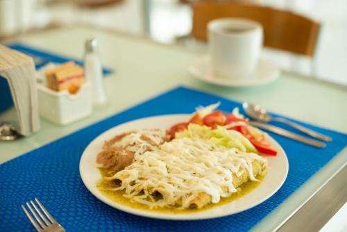 a plate of food with pasta and vegetables on a table at Best Western Centro Monterrey in Monterrey