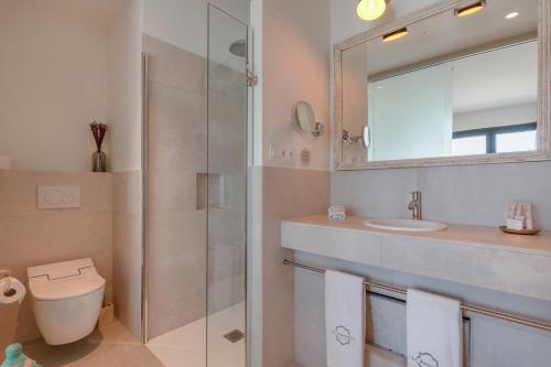 a bathroom with a toilet and a sink and a mirror at La Residencia Puerto Hotel & Spa in Tarifa