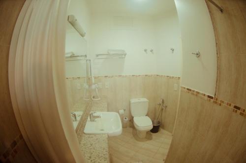 Hotel Marambaia Cabeçudas - frente mar في إيتاجاي: حمام مع مرحاض ومغسلة