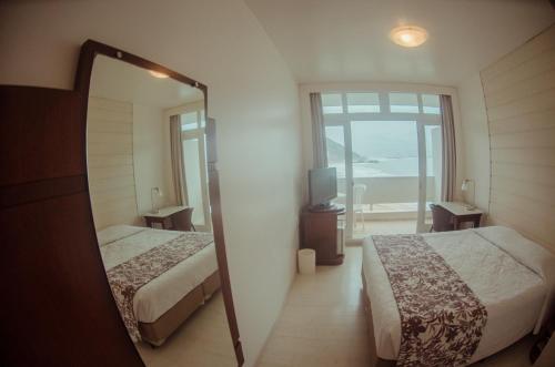 מיטה או מיטות בחדר ב-Hotel Marambaia Cabeçudas - frente mar