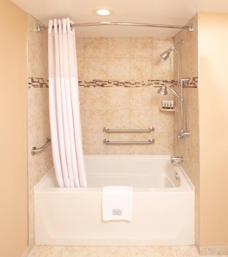 a bath tub with a shower curtain in a bathroom at Red Lion Hotel Orlando Lake Buena Vista South- Near Disney in Kissimmee
