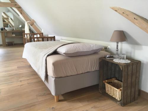 een slaapkamer met een bed en een tafel met een lamp bij Geetkotmolenhoeve in Lochristi