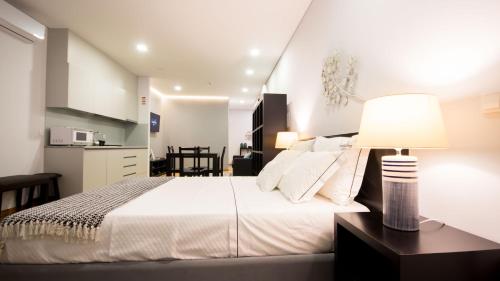 a bedroom with a bed and a table with a lamp at Bugalha My Loft Douro 4 in Peso da Régua