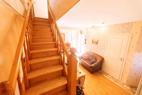 a wooden staircase in a living room with a couch at Hotel Veagles in Narva-Jõesuu