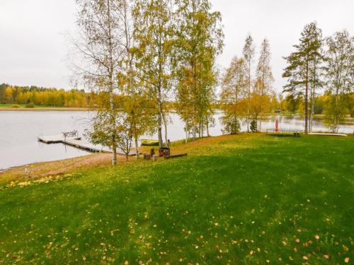 un parc avec un banc et un quai sur un lac dans l'établissement Holiday Home Vuorimaja by Interhome, à Kylänlahti