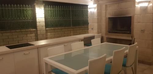 a kitchen with a table and white chairs in it at Appartamenti in villa Alessia in Monopoli
