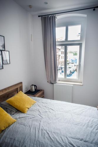 a bedroom with a bed and a window at Ahoj Apartments in Ustka