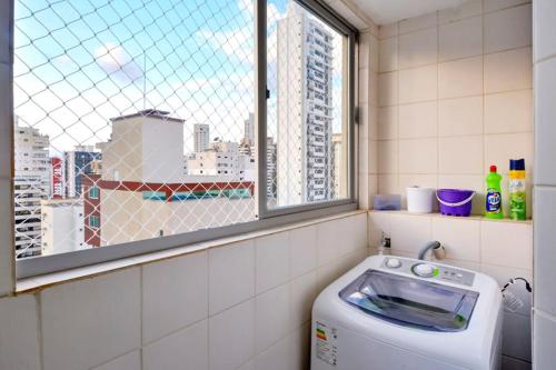 baño con lavadora y ventana en Apto no centro, com ótima localização, en Balneário Camboriú