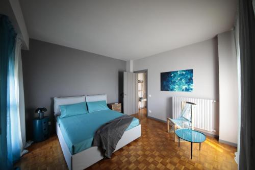 Schlafzimmer mit einem blauen Bett und einem Tisch in der Unterkunft Sunseeker - 80 Mq di terrazzo da sogno in Desenzano del Garda