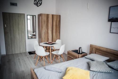 sypialnia z łóżkiem, stołem i krzesłami w obiekcie Ahoj Apartments w Ustce