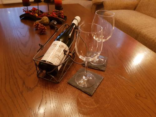 特拉本特拉巴赫的住宿－Ferienwohnung Liebeskummer，桌子上放有一瓶葡萄酒和两杯酒