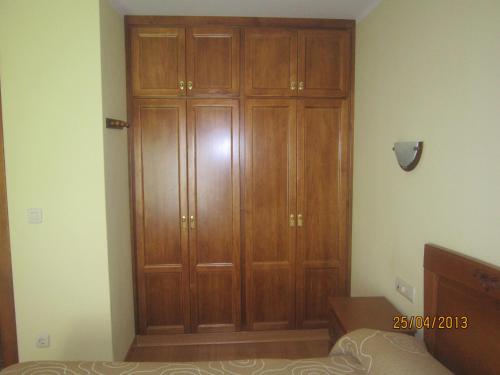 a large wooden closet in a room with a bed at Apartamentos Puente La Molina in Carreña de Cabrales 