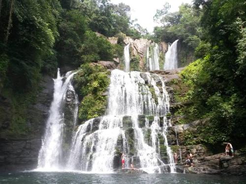 a waterfall in the middle of a body of water at Karandi Hostel in Uvita