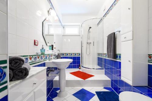 baño azul y blanco con lavabo y aseo en Orla Residence, en Varsovia