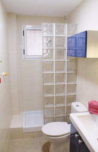 a bathroom with a toilet and a tub and a sink at Bungalow in Denia
