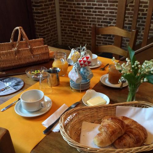 een tafel met een mand brood en een mand boter bij le chateau de PENIN in Penin
