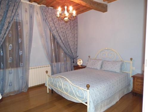 a bedroom with a white bed and a window at Casa Toscana in Lucca