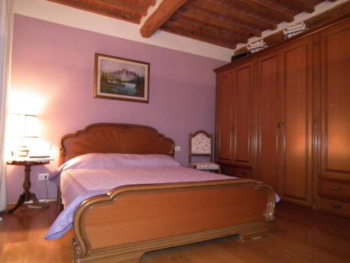 a bedroom with a wooden bed and a wooden cabinet at Casa Toscana in Lucca