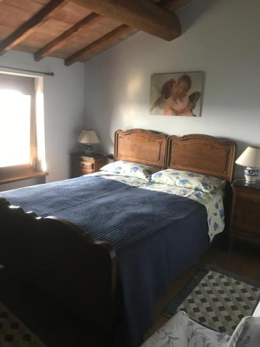 een slaapkamer met een bed met een blauw dekbed bij La Streghina Paolina in Verrua Savoia