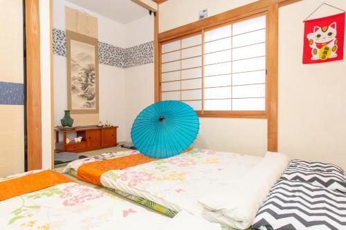 a bedroom with a bed with a blue fan on it at City Center House Next to Subway Station in Kyoto