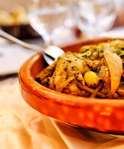 eine Schüssel mit Essen auf einem Tisch mit einem Löffel in der Unterkunft Riad Marwa Marrakech in Marrakesch