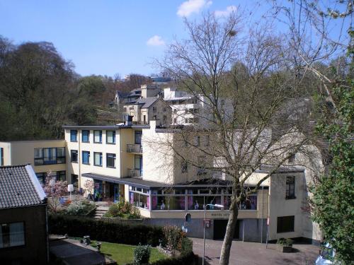 a building on top of a hill with houses at Hotel B&B LeLa in Valkenburg
