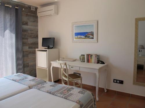 - une chambre avec 2 lits, un bureau et une télévision dans l'établissement Casa Agua Marina, à San José