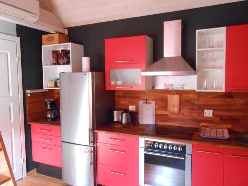 a kitchen with red cabinets and a refrigerator at Aablaranna Puhkemaja in Kolga-Aabla