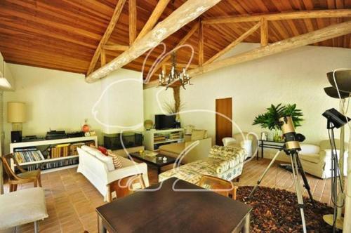 a living room with white furniture and wooden ceilings at Sitio proximo a SP lareira campinho e jacuzzi in Araçariguama