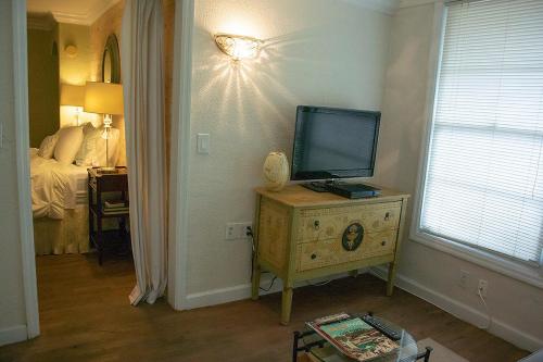 a room with a television on a dresser with a bed at Winter Park charm in Orlando