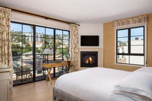 a bedroom with a bed and a fireplace and a desk at Hotel 850 SVB West Hollywood at Beverly Hills in Los Angeles
