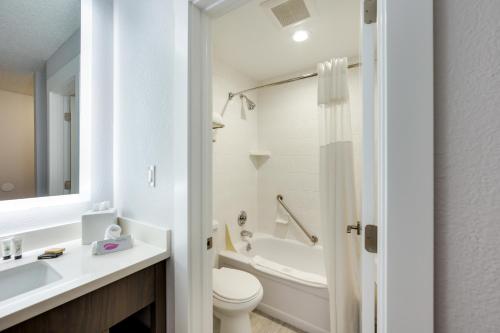 a white bathroom with a toilet and a sink at Red Lion Inn & Suites Grants Pass in Grants Pass