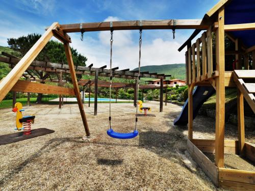a playground with swings and a slide at Apartment Altaluna-6 by Interhome in Nisporto