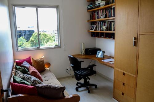 Habitación con escritorio, sofá y escritorio con ordenador. en Apartamento Sudoeste, en Brasilia