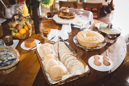 a table with bread and pastries and eggs on it at Pátio da Figueira in Torres Vedras