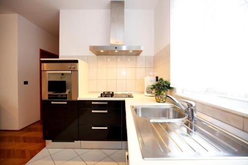 Il comprend une cuisine équipée d'un évier et d'une cuisinière. dans l'établissement City Gallery Apartment, à Zadar