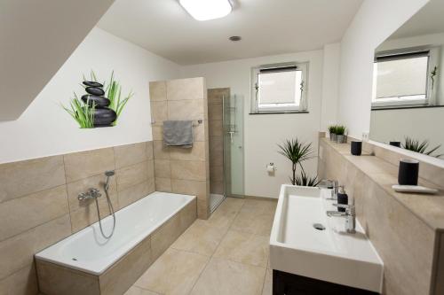 a bathroom with a tub and a shower and a sink at FeWo Zirndorf/Bronnamberg in Zirndorf