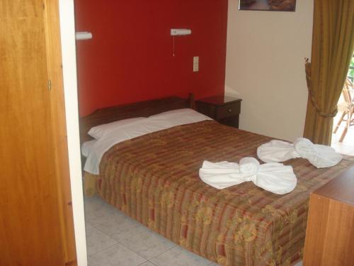 1 dormitorio con 1 cama con 2 toallas en Apolis hotel, en Mouzákion
