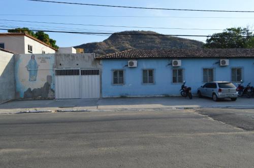a white car parked in front of a blue building at Pousada Ayrumã in Itapipoca