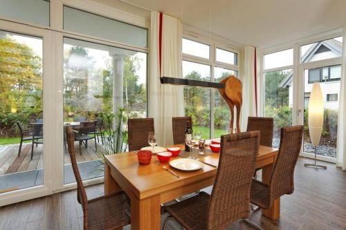 a dining room with a wooden table and chairs at Kapitaensweg 18 in Ostseebad Karlshagen