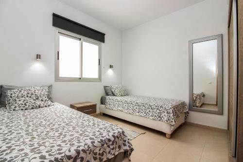 プエルト・デ・モガンにあるSunny Puerto de Moganのベッドルーム1室(ベッド2台、鏡付)