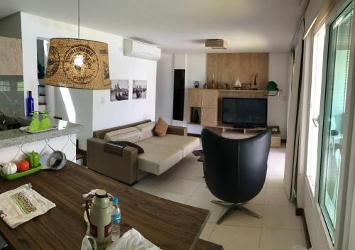 ein Wohnzimmer mit einem Sofa und einem TV in der Unterkunft Apartamento no Club Meridional in Praia dos Carneiros