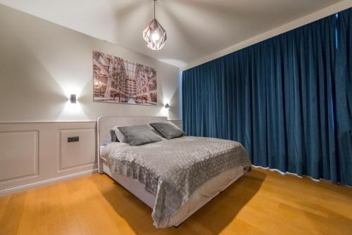 - une chambre avec un lit et des rideaux bleus dans l'établissement Studio des princes, à Liège