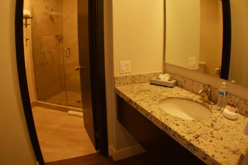 a bathroom with a sink and a mirror and a shower at Hotel America in Tijuana