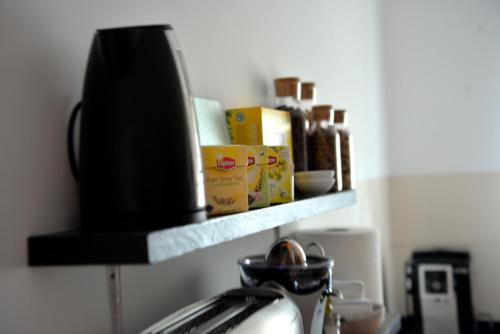 a kitchen counter with a shelf on the wall at Guesthouse Le Châtelain in Santa Maria