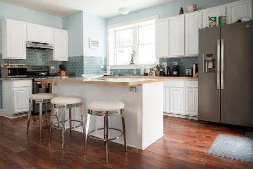 a kitchen with white cabinets and a counter with stools at The Greenleaf House in Chicago