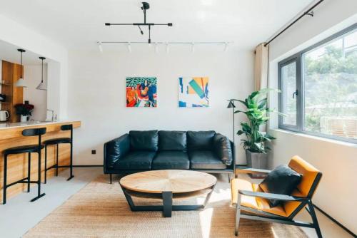 a living room with a black leather couch and a table at Simatai No.19 Villa in Miyun