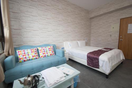a bedroom with a bed and a couch and a table at Yixiang Spring Travel in Jiaoxi