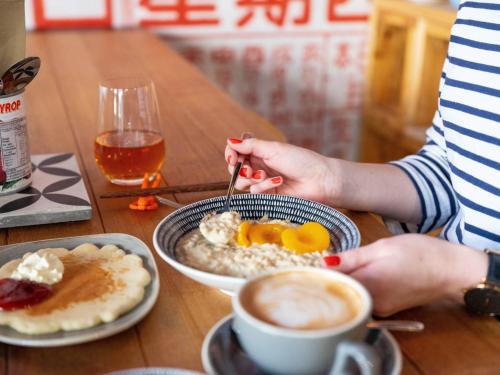 a person sitting at a table with a plate of breakfast food at Ibis Styles Hobart in Hobart